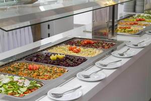 Buffet im Peninsula Resort & Spa mit verschiedenen Salaten, Tomaten und gegrillten Gerichten.