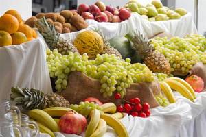 Obstbuffet im Peninsula Resort & Spa Hotel mit verschiedenen Früchten wie Äpfeln, Bananen und Trauben.