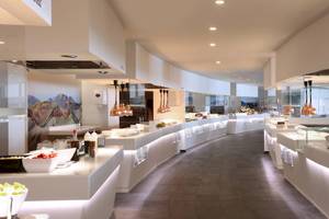 Innenansicht des Restaurants im Iberostar Selection Lanzarote Park Hotel mit modernen weißen Möbeln und heller Beleuchtung.