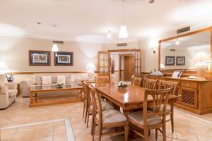 Speisezimmer im GF Gran Costa Adeje Hotel mit Esstisch, Stühlen und Dekor.