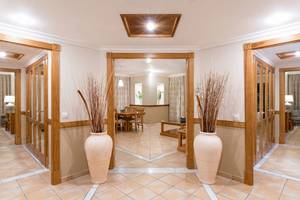 Innenbereich des GF Gran Costa Adeje Hotels mit gefliestem Boden und großen Vasen.