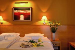 Doppelzimmer im Saudade Hotel mit einem Bett, Blumen, und einer dekorierten Wand.
