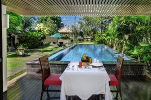 Außenesstisch am Pool im Prama Sanur Beach Bali Hotel mit Blick auf den Garten