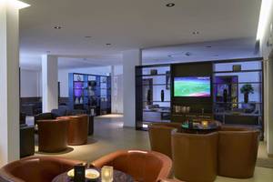 Loungebereich des Melia Dunas Beach Resort mit Fernseher und Lederstühlen.