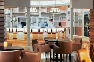 Innenansicht der Rezeption im H10 Playa Esmeralda Hotel mit Angestellten und Möbeln.