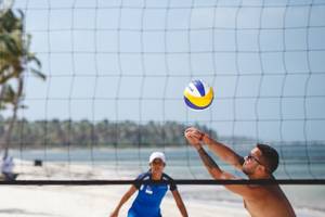 Strandvolleyballspiel bei Catalonia Royal Tulum mit Hotel im Hintergrund