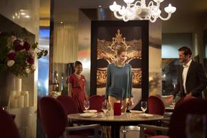 Ein eleganter Tisch im Park Rotana Abu Dhabi Hotel mit einer Frau und einem Mann, die sich unterhalten.