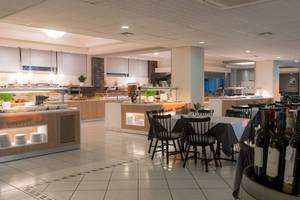 Frühstücksraum im Elea Beach Hotel mit Tischen, Stühlen und Buffet.