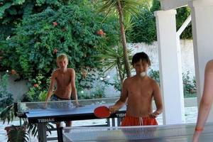 Junge spielen Tischtennis im Freien im Hotel Elea Beach.