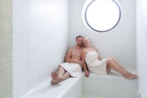 Ein Paar sitzt in einem Dampfbad im Tigotan Lovers & Friends Hotel.