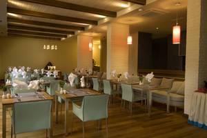 Innenbereich des Restaurants im Casa De Maris Spa & Resort mit gedeckten Tischen und Stühlen.