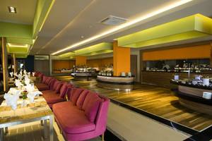 Innenansicht des Restaurants im Casa De Maris Spa & Resort mit Holzboden und pinken Sofas.