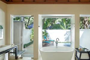 Badezimmer im Hilton Seychelles Labriz Resort & Spa mit Badewanne, Dusche und Blick auf den Garten.
