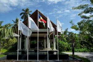 Eingang des Hilton Seychelles Labriz Resort & Spa mit mehreren Flaggen vor dem Gebäude.