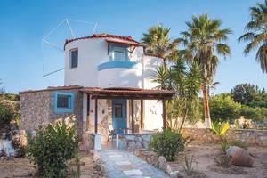 Außenansicht der Eurovillage Achilleas Villa mit Steinmauern und Palmen