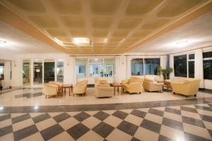 Empfangsbereich des Hotels Eurovillage Achilleas mit gemusterten Böden und weißen Wänden.