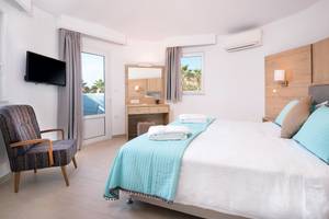 Schlafzimmer im Eurovillage Achilleas Hotel mit Doppelbett, Fernseher und Klimaanlage.