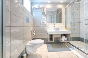 Badezimmer im Eurovillage Achilleas Hotel mit moderner Einrichtung und Glasdusche.