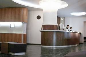Empfangsbereich des Ku Damm 101 Hotels mit modernem Design und Holzakzenten.