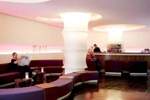Lobbybereich des Ku Damm 101 Hotels mit Sitzbereichen und Bar.