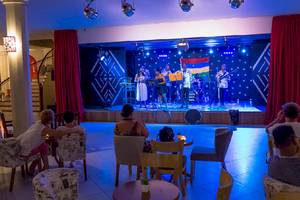 Le Peninsula Bay Beach Resort & Spa mit einer Band, die auf der Bühne auftritt, während Gäste zuschauen.