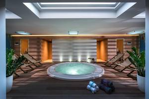Jacuzzi-Bereich im Corissia Princess Hotel mit Lounge-Stühlen und Pflanzen.