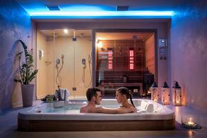 Paar im Whirlpool im Corissia Princess Hotel mit beleuchteten Wänden und einer Sauna im Hintergrund