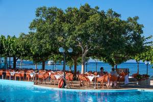 Sitzgelegenheiten im Freien am Pool des Corissia Princess Hotels, mit Blick auf das Meer.