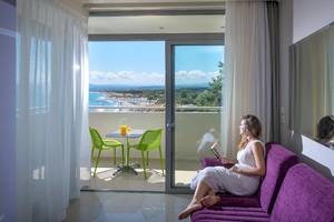 Frau auf dem Balkon des Corissia Princess Hotels mit Meerblick