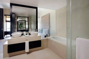 Badezimmer im Southern Sun Abu Dhabi Hotel mit zwei Waschbecken und Badewanne.