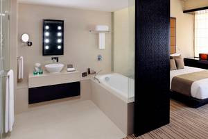 Hotelzimmer mit Badezimmer und Bett im Southern Sun Abu Dhabi