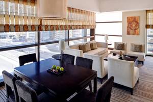 Innenansicht einer Suite im Southern Sun Abu Dhabi Hotel mit Möbeln und Blick auf die Stadt.