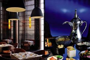 Restaurant des Southern Sun Abu Dhabi mit Tischen und Speisen im Vordergrund, eine Karaffe im Hintergrund.
