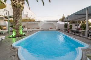 Ein Swimmingpool im Freien im Beach Boutique Hotel mit Liegestühlen und Sonnenschirmen.
