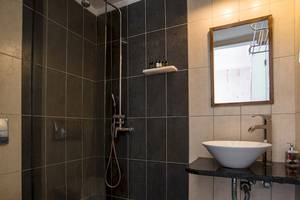 Badezimmer im Beach Boutique Hotel mit schwarzer Wandfliesen und weißem Waschbecken.
