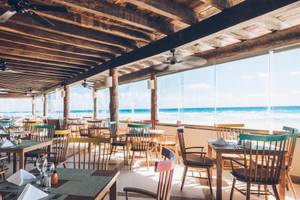 Innenansicht des Restaurants im Iberostar Selection Cancun mit Blick auf den Ozean.