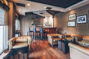Hotellounge im Iberostar Selection Cancun mit Bar, Sesseln und Bildern an der Wand.