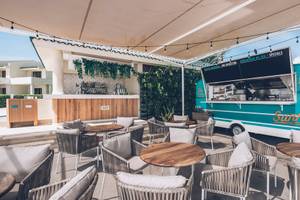 Terrasse des Iberostar Selection Cancun Hotels mit Sitzgelegenheiten und einem Café-Truck.