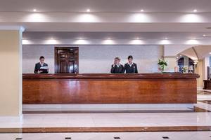 Empfangsbereich des Mitsis Grand Hotel Beach mit zwei Mitarbeiterinnen am Empfangsschalter.