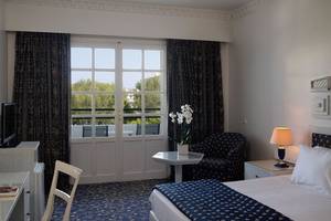 Ein elegant eingerichtetes Hotelzimmer mit Doppelbett, Tisch, Stuhl und Fernseher.