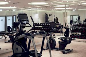 Fitnesscenter im Santo Pure Oia Suites & Villas Hotel mit vielen Geräten und Spiegeln.