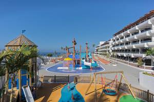 Außenbereich des H10 Atlantic Sunset Hotels mit einem großen Kinderspielplatz, Wasserrutschen und einer Wasserfontäne.