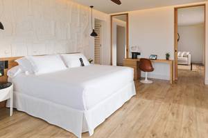 Schlafzimmer im H10 Atlantic Sunset Hotel mit weißem Bett, Holzboden und moderner Einrichtung.