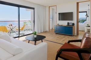 Innenansicht der Suite im H10 Atlantic Sunset Hotel mit Blick auf das Meer, einem modernen Wohnzimmer und einer Terrasse.