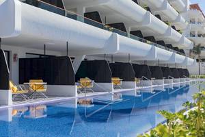 Außenpool des H10 Atlantic Sunset Hotels mit gelben Stühlen und modernen Gebäuden im Hintergrund.