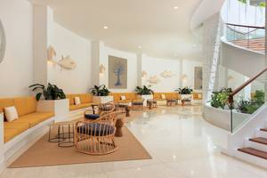 Lobby des H10 Atlantic Sunset Hotels mit gelben Sofas, runden Stühlen und Pflanzen.