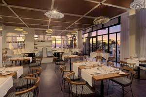 Innenraum des Restaurants des H10 Atlantic Sunset Hotels mit geometrischen Lampen und Blick auf den Ozean.