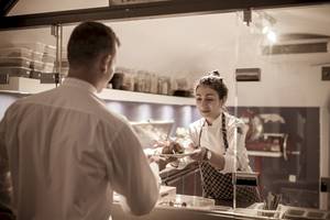Chef serviciert Kunden im Katikies Chromata Santorini