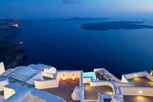 Aussicht vom Katikies Chromata Hotel in Santorini bei Nacht mit Meer und Inseln im Hintergrund.