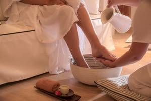 Gast im Hotel Katikies Chromata Santorini genießt eine Fußmassage.